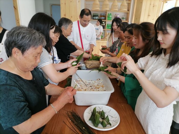 游客们正在体验包粽子