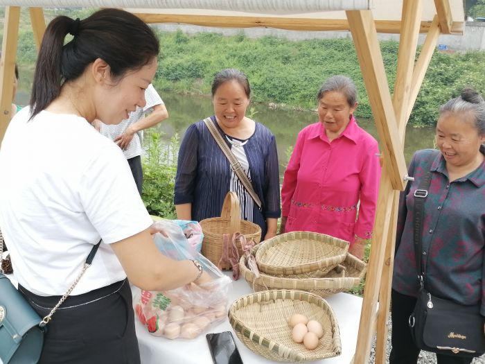 在该村市集上，游客正在购买土特产