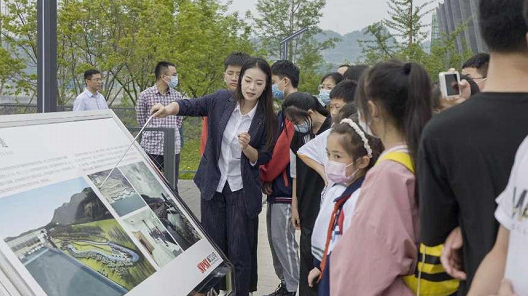 在展板前，解说员耐心向学生们介绍仿生鱼道