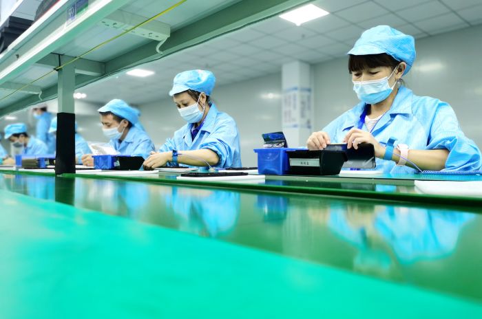 在位于仁寿县经济开发区的卓航电子科技有限公司，工人们正在生产线上组装手机.jpg