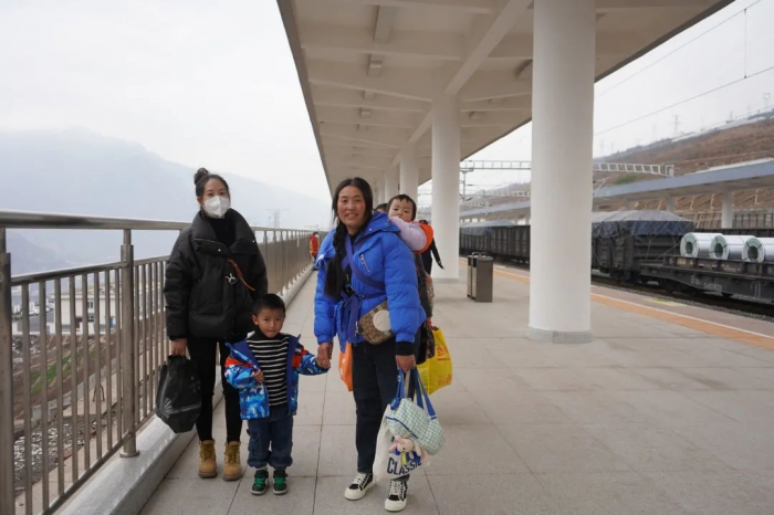 从云南探亲的介达女士牵着孙儿孙女的手回到峨边