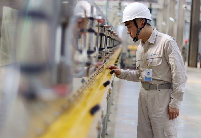 四川协鑫锂电年产36万吨磷酸铁锂储能材料项目一期生产车间内，工人正在巡视生产线.jpg