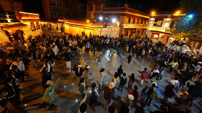 图为游客和当地群众跳起欢快的锅庄舞.jpg