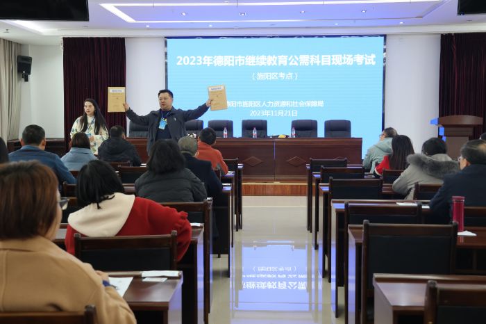 图为：旌阳区人社局工作人员向参加考试人员展示试卷密封性