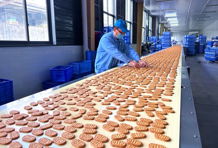 在位于仁寿县经济开发区内的四川省饼之源食品有限公司生产车间内，工人们正在流水线上忙碌地工作.jpg