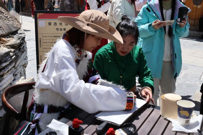 2图为游客体验藏族传统技艺.JPG