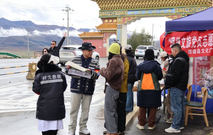 图为志愿者为游客介绍旅游景点.jpg