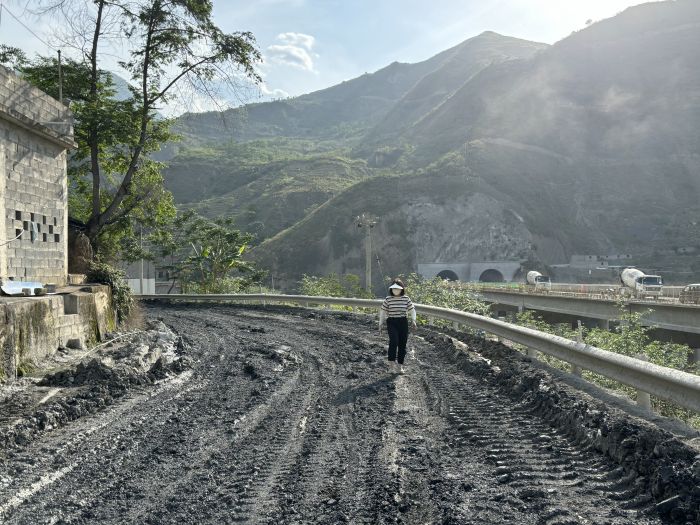 探寻金沙江采访组记者行走泥泞道路前往卡哈洛大桥采访
