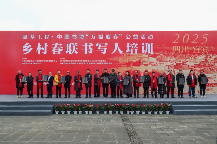 春联书写专家与宜宾10名基层书法爱好者“结对子”并赠送教材。 庄歌尔 摄