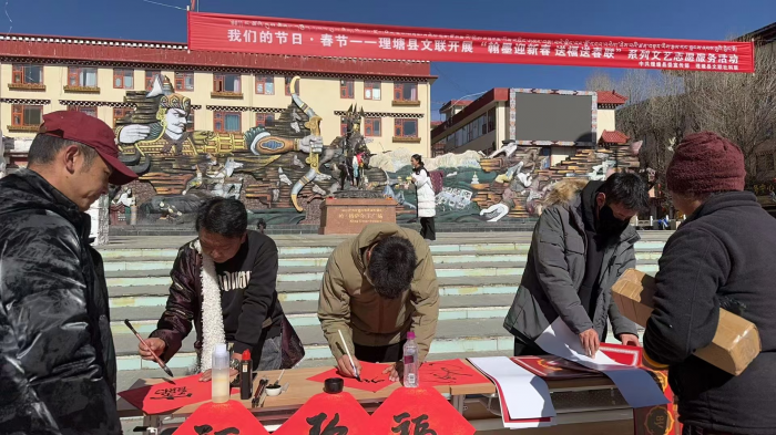 图为书法老师为居民书写藏汉文春联.png