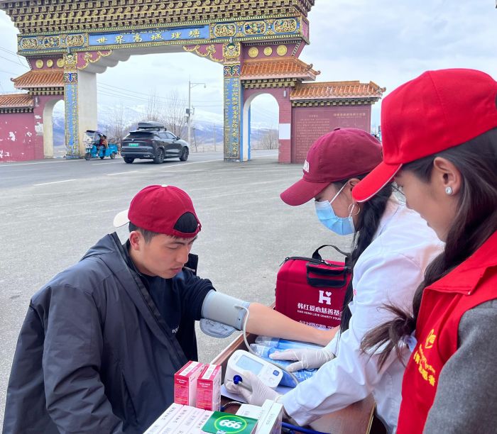 图为理塘县文旅志愿者为游客量血压.jpg