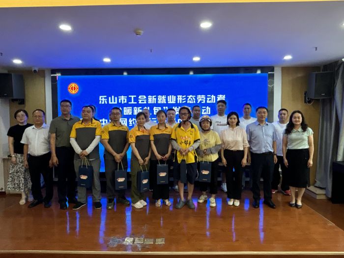 与会领导为新就业形态劳动者代表发放“暖新礼包”。