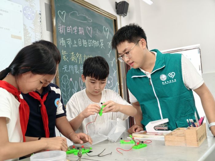 国网石棉县供电公司志愿者在石棉县草科乡中心小学，与同学们共同完成电路连接实验。.jpg