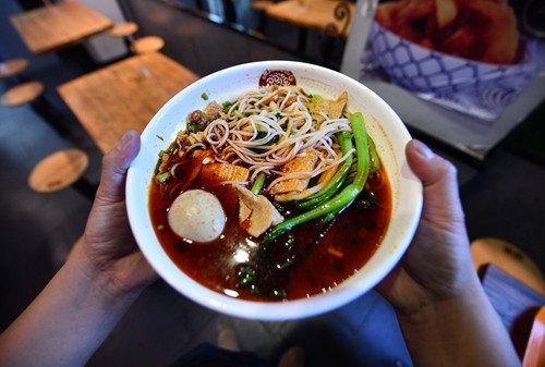 1月2日，在柳州市一家螺蛳粉店，顾客端着一碗螺蛳粉准备食用。 新华社记者 黄孝邦 摄.JPG