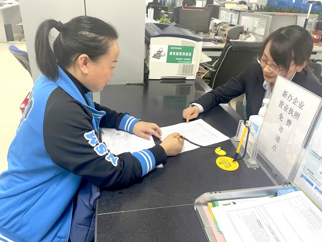 综合窗口工作人员指导群众填写资料.jpg